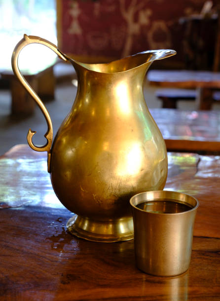 istock Brass water jug and glass filled with water 1983817052