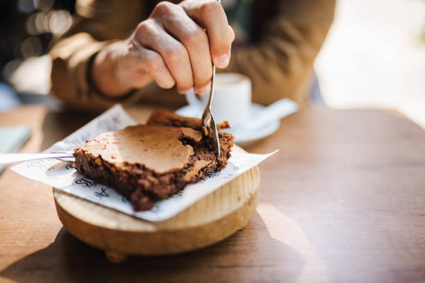 walnut chocolate brownie with vanilla ice cream and peanut, chocolate sauce, mint leaf dessert in round plate on white table western asian cafe halal dessert restaurant pastry menu