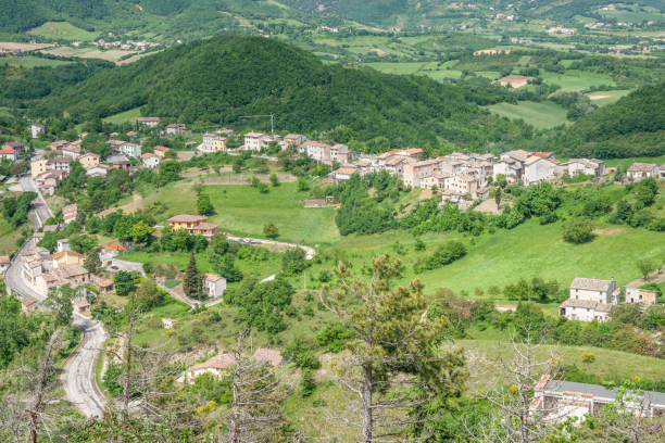 istock Road winding through rolling landscape to village 1983861114
