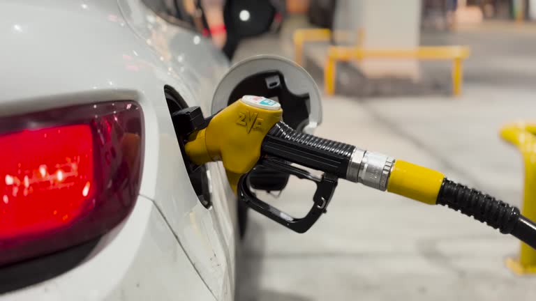 Car being refueled with yellow fuel gun, Gas Station