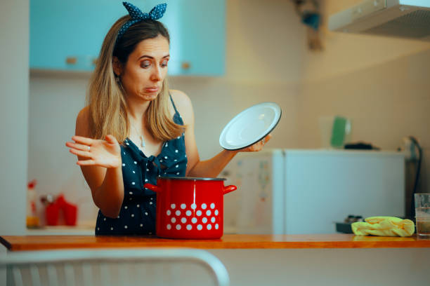 istock Woman Looking Disgusted into a Cooking Pot in the Kitchen 1983889808