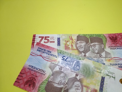 Close up view of Indonesian banknote Special edition 75000 Rupiah. Issued by Bank Indonesia for celebrate 75th Independence Day in 2020. Yellow background. Finance concept.