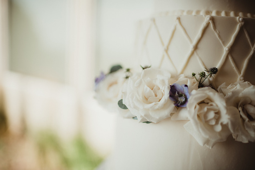 Close up of a wedding cake with white roses