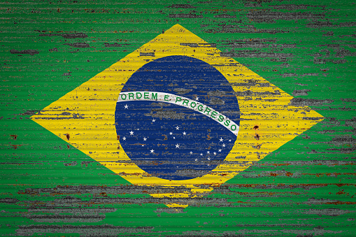 Close-up of old metal wall with national flag of Brazil . Concept of Brazil  export-import, storage of goods and national delivery of goods. Flag in grunge style