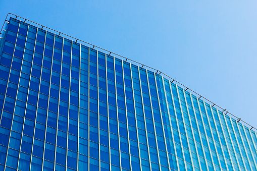 Low angle angular view of a corporate building against a blue sky