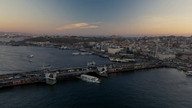 Sunset on Istanbul Peninsula, Aerial view of the Golden Horn in Istanbul, Multiple residential buildings, mosques, Galata bridge over the Golden Horn waterway with multiple floating ships