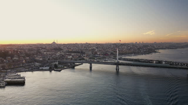 Sunset on Istanbul Peninsula, Aerial view of the Golden Horn in Istanbul, Multiple residential buildings, mosques, Galata bridge over the Golden Horn waterway with multiple floating ships