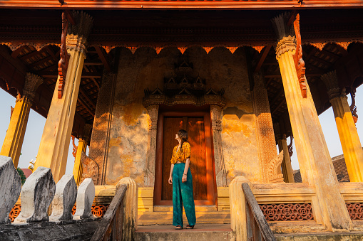 Serene woman exploring Laotian buddhist temple in Vientien