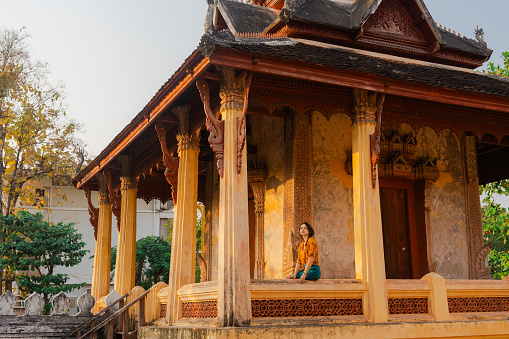 Serene woman exploring Laotian buddhist temple in Vientien