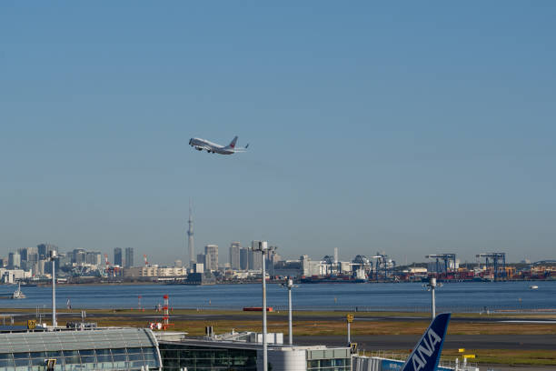 Tokyo, Japan – Nov.20th, 2023: Japan Airlines airplane taking off from Tokyo Haneda Airport with the Tokyo Skytree and the skyscrapers background.
