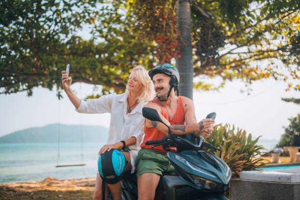A young couple on a motorcycle. They enjoy the day, traveling through the beautiful nature on the Ko Samui island, Thailand.