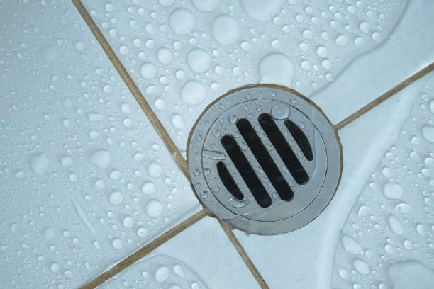 Water flowing over into metal drain in showerroom.