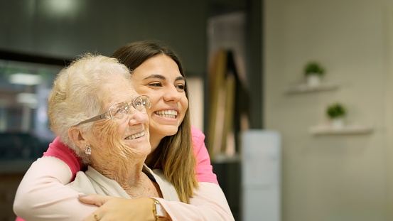 Picture of smiling grandmother and granddaughter looking at copy space