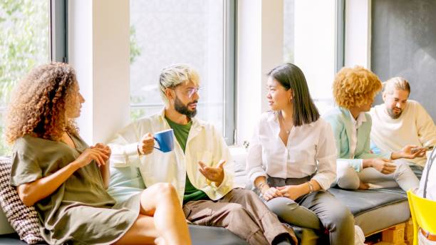 istock Coworkers chatting relaxed during coffee break sitting on chairs 1984462539