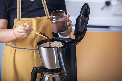 Young woman making coffee on coffee machine