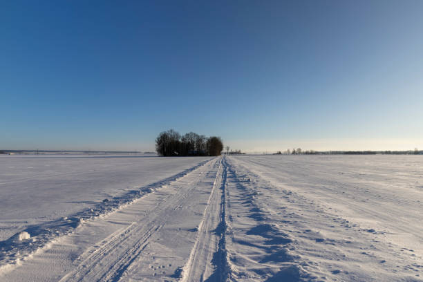 a snow- covered road in winter , a slippery and dangerous road covered with snow and ice