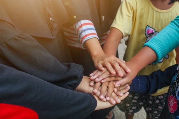 istock a group of children put their hands together. 1984533263