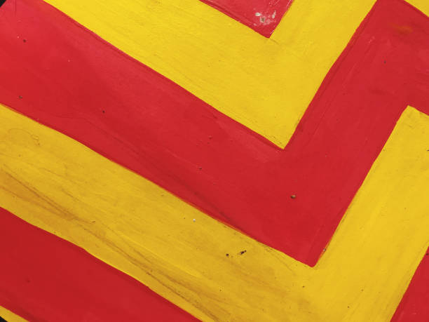 Yellow and red stripes painted on a metal surface. Abstract background.