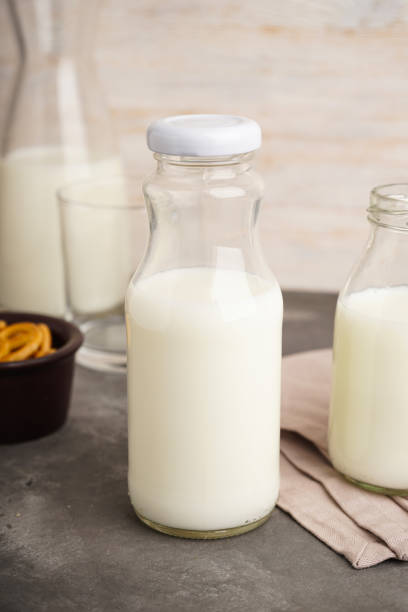 istock Milk in jar and glass on the grey background. 1984561557