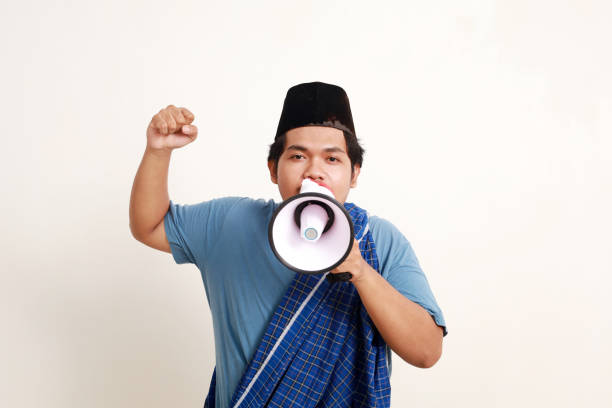 istock Asian muslim boy standing shouting with megaphone while making fist hand 1984594220