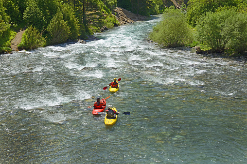 Colorful kayaks on the Ara river, Valley of Bujaruelo in the Aragonese Pyrenees, Huesca, Spain - kayaks in the Ara river rapids