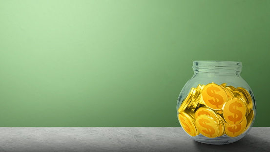 Golden dollar coin-filled glass jars on the table. Financial saving concept