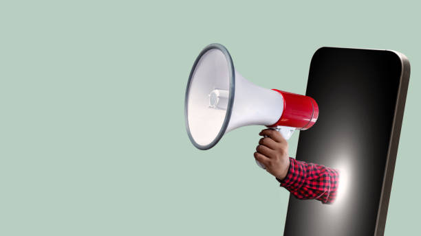 istock A human hand holding a megaphone comes out from the mobile phone screen 1984685929