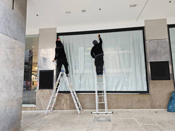 two men window cleaners at work on a window front stock photo