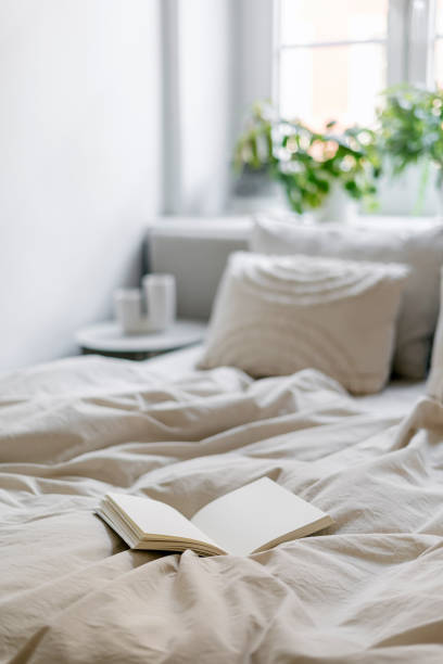 istock Open paper notebook on bed with blanket and pillows in cozy bedroom 1984724183