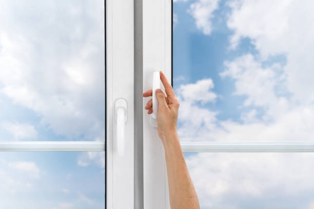 istock Cropped view on female hand hold handle and open pvc window to ventilate room 1984724609