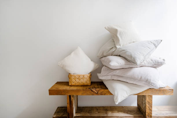 istock Wicker laundry basket with small cushion close to pillow in white pillowcases 1984725121