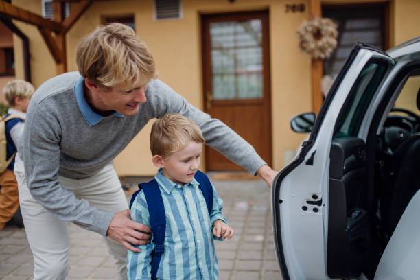 istock School boy getting into the car. Father taking son to school before going to work. 1984732901