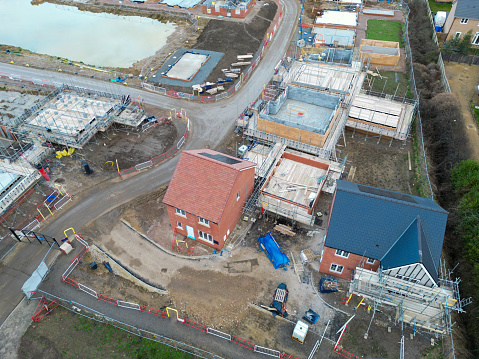 Drone view of part finished new and affordable homes seen in an English housing development. Solar panels are seen fitted to the new houses at the front of the site.