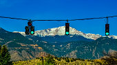 Traffic light on the background of snow-capped mountains. Pikes Peak Mountains in Colorado Spring, Colorado, US