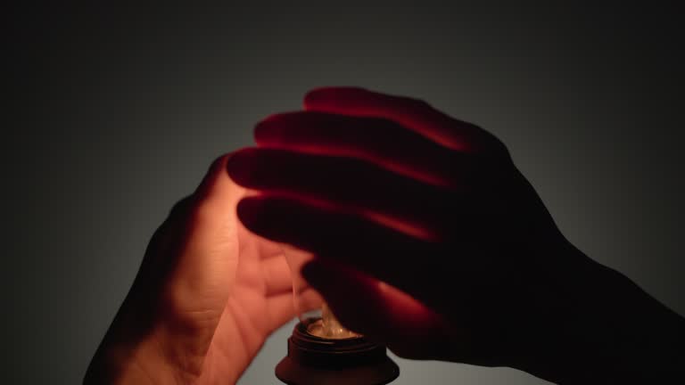 Human hands surrounding a flickering weak light bulb