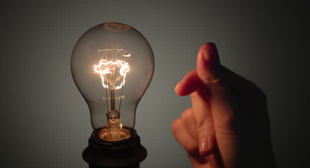 Light bulb turning on and off when human hand snaps fingers