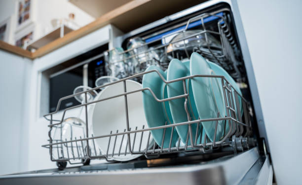 istock The white kitchen and opened dishwasher with clean dishes 1984801698