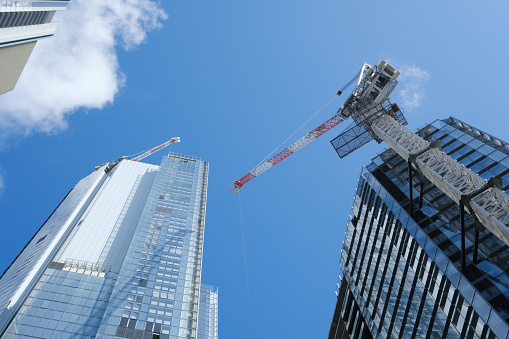 Tall buildings with deep blue sky and construction cranes.