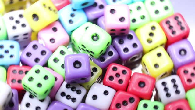 many mini cubic six-sided gaming dice rolled for playing
