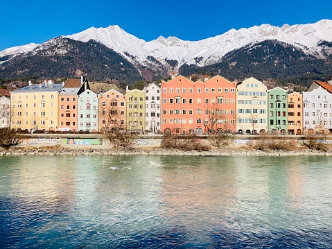 Innsbruck traditional buildings and Alpine peak by the river and the Austrian Alps, in Tyrol
