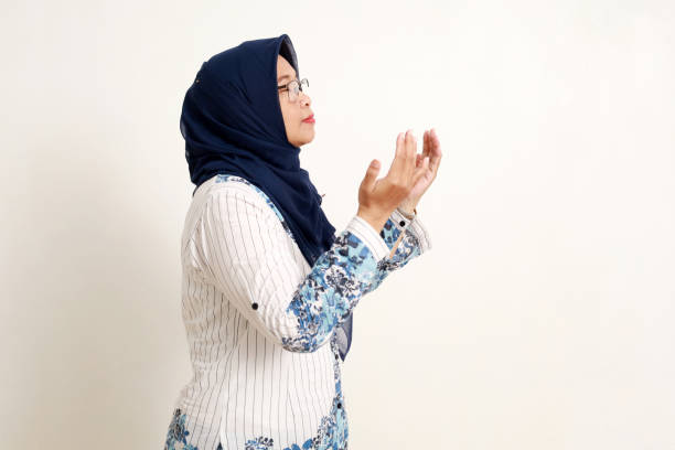 istock Asian elderly muslim woman standing while praying. Side view. Isolated on white 1984858677
