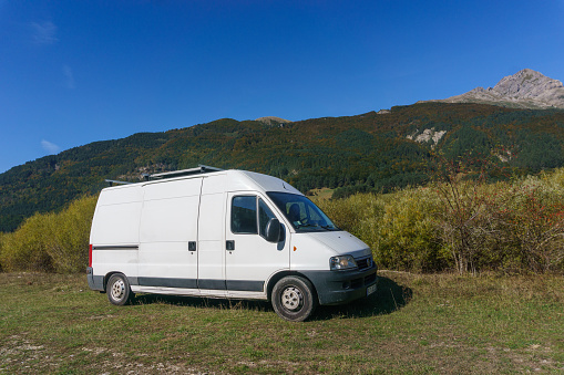 Camper Van in mountain landscape in Pyrenees Mountains with forest during autumn near Isaba, Navarre, Spain