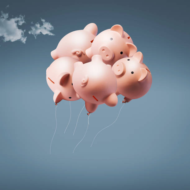 istock Balloon piggy banks flying away 1984880193