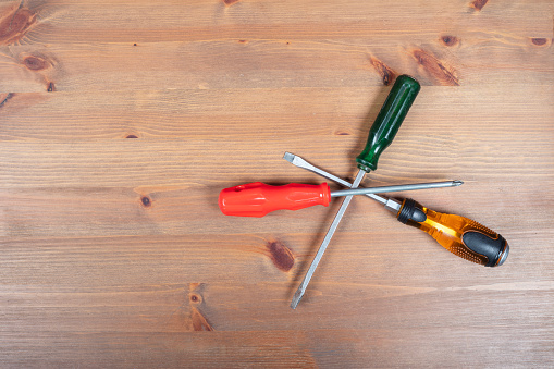 Types of repair tools, screwdrivers on wooden floor.
