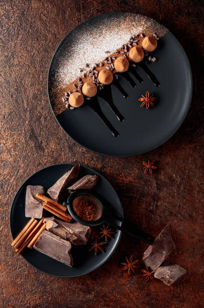 istock Chocolate truffles on a black plate with chocolate sauce. 1984915814