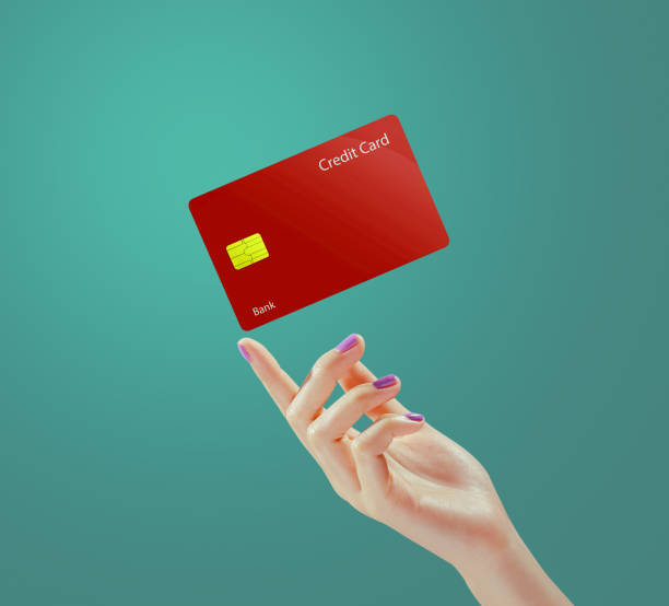istock Hand holding red credit card on green background. 1984925720