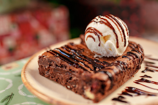 A slice of brownie with vanilla icecream on top.