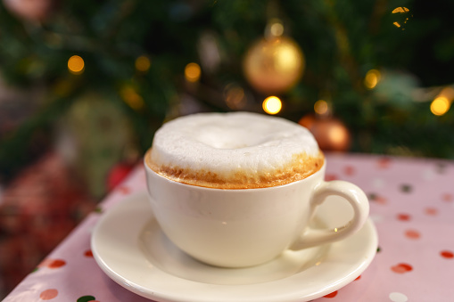 Cappuccino with christmas tree decoration background