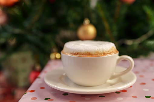 Cappuccino with christmas tree decoration background