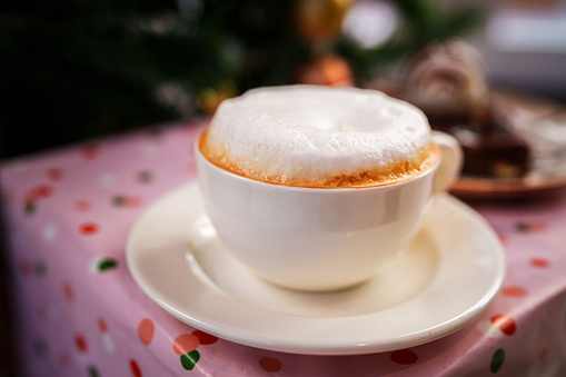 Cappuccino with christmas tree decoration background